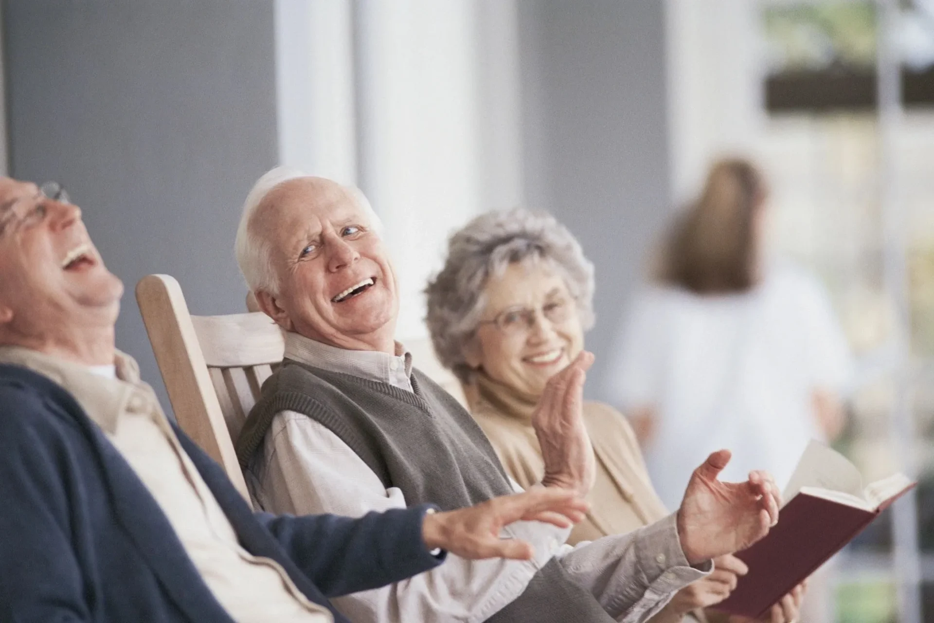 A man and woman sitting in chairs laughing.